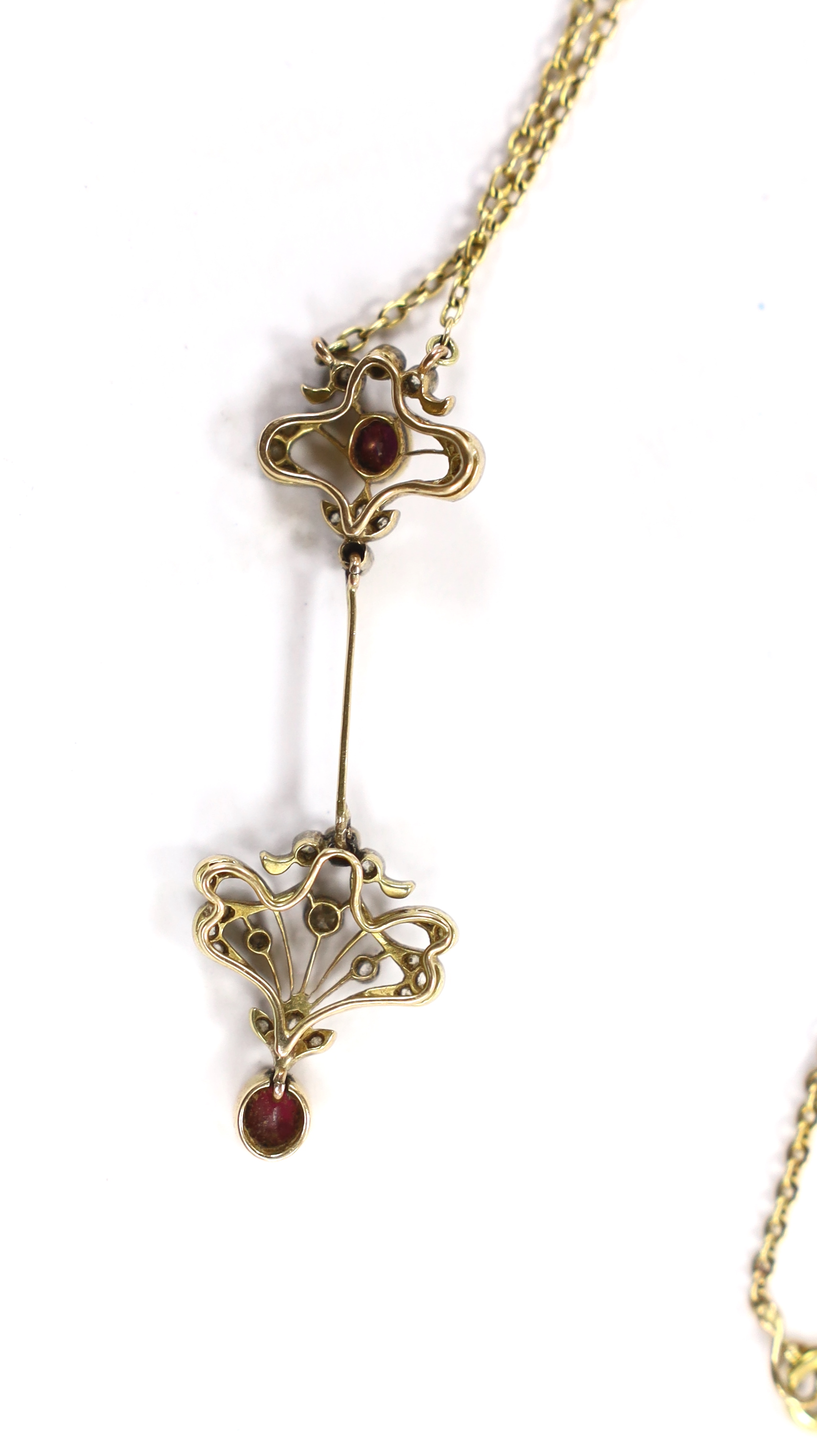 A Belle Epoque yellow metal and millegrain set ruby and diamond drop pendant necklace, the chain bale stamped 9ct, pendant 46mm, chain 47cm, gross weight 5.4 grams.
